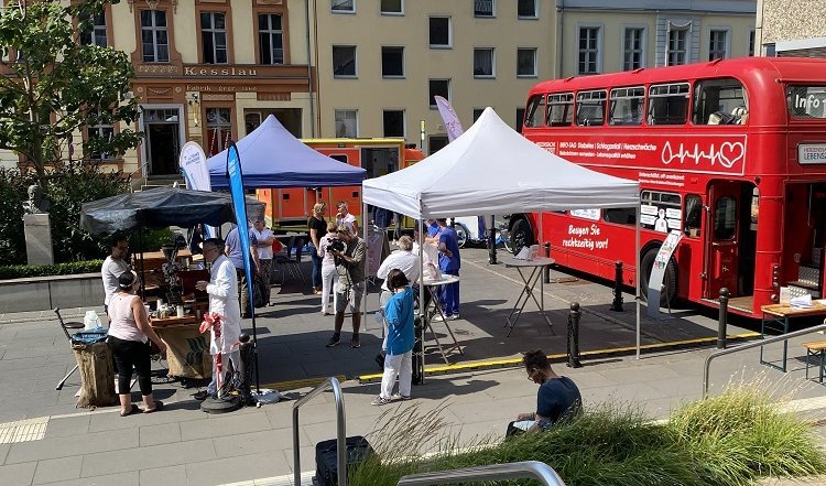 Signalroter London-Infobus der Aufklärungskampagne „Herzenssache Lebenszeit“ vor Potsdamer Klinikum Ernst von Bergmann
